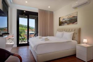 a bedroom with a white bed and a balcony at Georgiy Lux Apartments in Lastva +34 photos