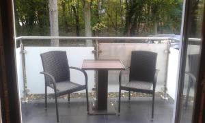 - deux chaises et une table sur une terrasse couverte avec une table et des chaises dans l'établissement Apartament JULIA, à Świnoujście