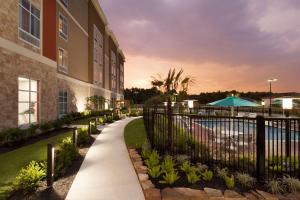 a walkway next to a building with a pool at Homewood Suites by Hilton North Houston/Spring in Spring