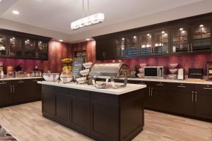 a large kitchen with dark cabinets and a large island at Homewood Suites by Hilton North Houston/Spring in Spring
