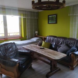 a living room with leather furniture and a wooden table at Noclegi w pobliżu Energylandii - Agroturystyka Radocza Ogród in Radocza