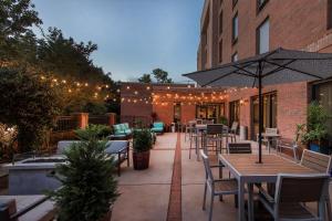 a patio with tables and chairs and an umbrella at Hampton Inn Wilmington University Area in Wilmington