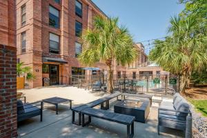 un patio con panche e tavoli di fronte a un edificio di Hampton Inn Wilmington-Medical Park a Wilmington