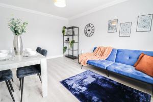 a living room with a blue couch and a table at NEW BUILD house with GATED DRIVEWAY! FREE wifi! in Luton