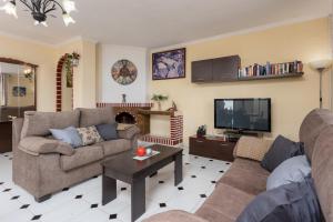 a living room with two couches and a tv at Villa Las Palomas in Frigiliana