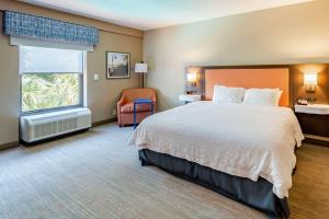 una camera d'albergo con un grande letto e una sedia di Hampton Inn Wilmington-Medical Park a Wilmington