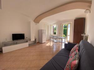 sala de estar con sofá y TV en Villa Vanda, en Castelveccana