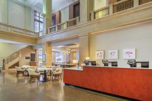 a lobby with a waiting area with chairs and a counter at Hilton Garden Inn Indianapolis Downtown in Indianapolis