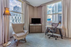 a hotel room with a desk and a chair and a computer at Hilton Garden Inn Indianapolis Downtown in Indianapolis