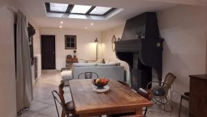 a living room with a table and a fireplace at Cottage Gîte près du lac de Madine et Verdun sites de Guerre in Heudicourt-sous-les-Côtes