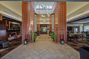 een lobby met twee hoge zuilen met tafels en stoelen bij Hilton Garden Inn Indianapolis Northeast/Fishers in Fishers