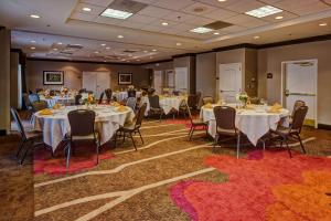 uma sala de banquetes com mesas e cadeiras e pessoas sentadas a eles em Hilton Garden Inn Indianapolis Northeast/Fishers em Fishers