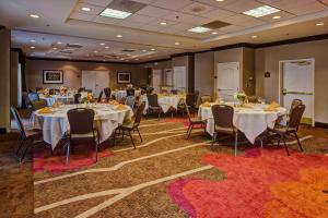 een banketzaal met tafels en stoelen en mensen die er zitten bij Hilton Garden Inn Indianapolis Northeast/Fishers in Fishers