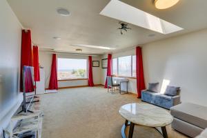 a living room with red curtains and a couch and a table at Seaside Eureka Vacation Rental with Bay Views! in Eureka