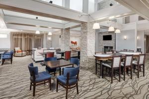 a dining room with tables and chairs and a fireplace at Homewood Suites by Hilton Indianapolis At The Crossing in Indianapolis