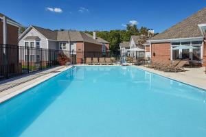 una gran piscina azul frente a algunas casas en Homewood Suites by Hilton Indianapolis At The Crossing, en Indianápolis