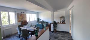 a living room with a table and a couch and a table and chairs at Bel appartement lumineux 3 chambres in Lay-Saint-Christophe +4 photos