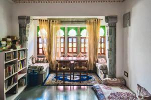 a living room with a table and chairs and a window at Lassi Boutique Hotel in Udaipur