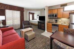 a hotel room with a kitchen and a living room at Homewood Suites by Hilton Indianapolis At The Crossing in Indianapolis