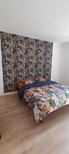 a bed in a room with a headboard at Bel appartement lumineux 3 chambres in Lay-Saint-Christophe