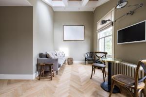 salon z kanapą i telewizorem w obiekcie The Notting Hill Apartments By Hok Living - Nh4 w Londynie