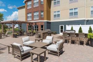 a patio with chairs and tables in front of a building at Homewood Suites by Hilton Indianapolis Airport / Plainfield in Plainfield