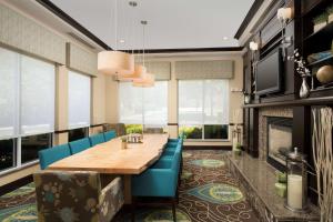una sala da pranzo con tavolo, sedie e camino di Hilton Garden Inn Winston-Salem/Hanes Mall a Winston-Salem