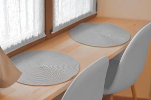 two mats on a table with chairs and a window at Baceno Room in Baceno