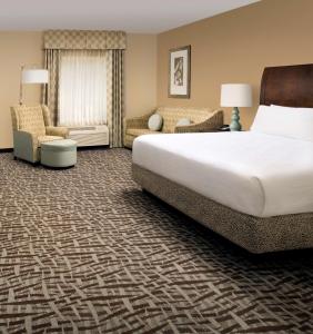 a hotel room with a large bed and a couch at Hilton Garden Inn Winston-Salem/Hanes Mall in Winston-Salem