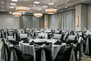 um salão de banquetes com mesas e cadeiras brancas em Hilton Garden Inn Iowa City Downtown University em Iowa City