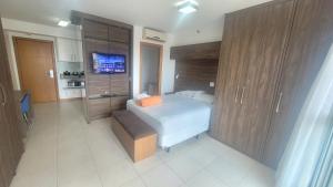 a bedroom with a bed and a flat screen tv at Saint Moritz Express vista Esplanada By Rei dos Flats in Brasilia