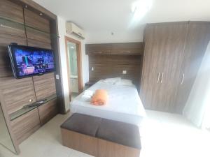 a small bedroom with a bed and a tv at Saint Moritz Express vista Esplanada By Rei dos Flats in Brasilia