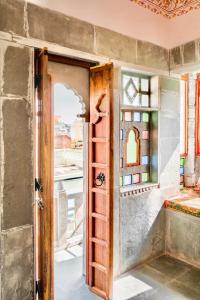 ウダイプールにあるLassi Guest Houseの窓付きの部屋の開口ドア