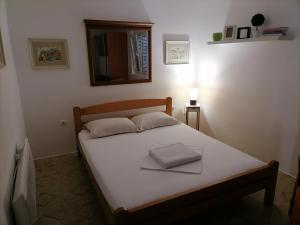 1 cama en un dormitorio con espejo en la pared en Apartment Casa sul Mare, en Tivat