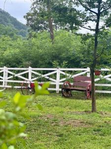 a red wagon sitting next to a white fence at CAMPING THOBIAS in Alunu