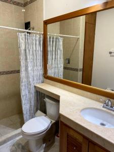 a bathroom with a toilet and a sink and a mirror at Quinta Sea in Playa del Carmen +73 photos