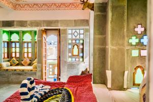 een kamer met een bed en een aantal ramen bij Lassi Guest House in Udaipur