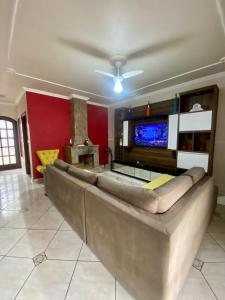 a living room with a large couch and a tv at Refúgio solar in Socorro