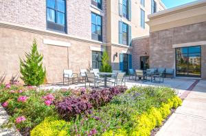 un patio con sillas y flores frente a un edificio en Hampton Inn & Suites Ridgeland, en Ridgeland
