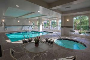 麥迪遜的住宿－傑克遜-麥迪遜希爾頓花園酒店，一个带桌椅的房间的游泳池