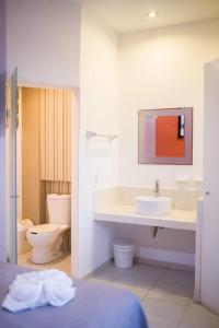 La salle de bains blanche est pourvue d'un lavabo et de toilettes. dans l'établissement HOTEL OBREGON, à Iguala de la Independencia