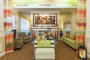 a lobby with a couch and a table in a room at Hilton Garden Inn Jacksonville Airport in Jacksonville