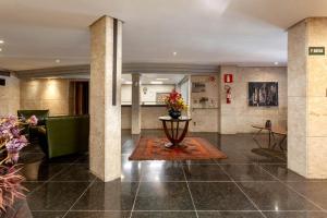 a lobby with a couch and a table with flowers at Savassinho Hotel & Residence in Belo Horizonte