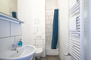 2 Bedroom Apartment (ABEMI) في برلين: حمام أبيض مع حوض ومرحاض