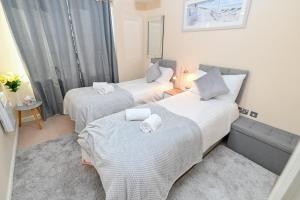 een kamer met 2 bedden en handdoeken erop bij One Bedroom Apartment TCA-78 in Watford