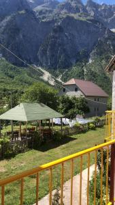 a table with a green tent in front of a mountain at Bujtina Kometa in Theth