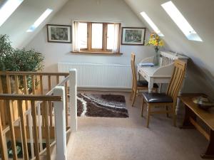 Habitación con mesa, sillas y ventana en The Oak Lodge, Clematis Cottages, Stamford, en Stamford