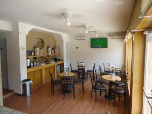 une salle à manger avec des tables, des chaises et une télévision dans l'établissement Hotel Zafra, à Torreón