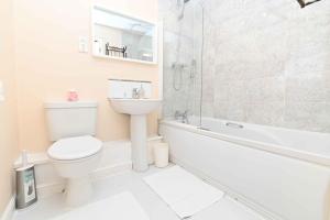 een badkamer met een toilet, een wastafel en een bad bij One Bedroom Apartment TCA-78 in Watford