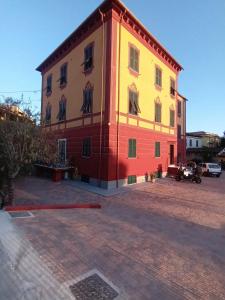a yellow and red building on a brick street at AFFITTACAMERE SobborgoSpina47 in Sarzana